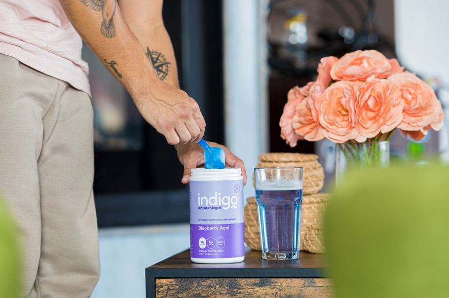 Man Putting Indigo Marine Collagen Peptides into a Glass of Water